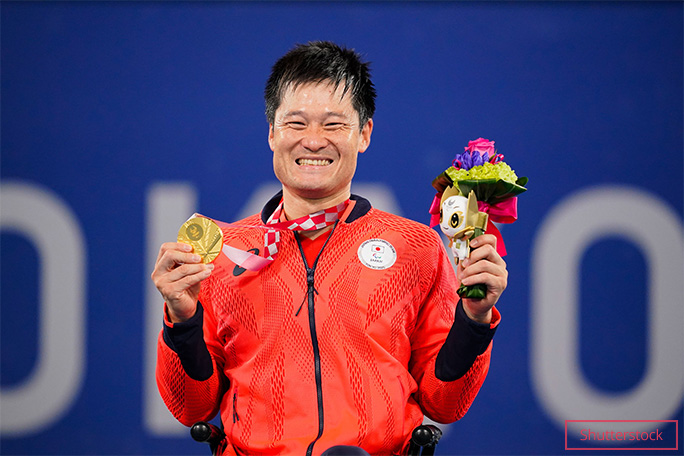 Shingo Kunieda holding a medal and flowers